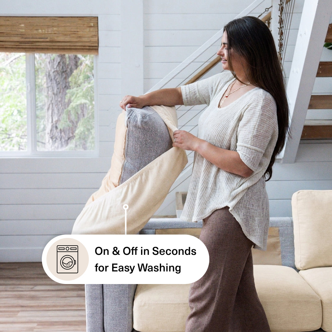 Woman fitting a Cream Miracle Sofa Cover Plush onto a back cushion