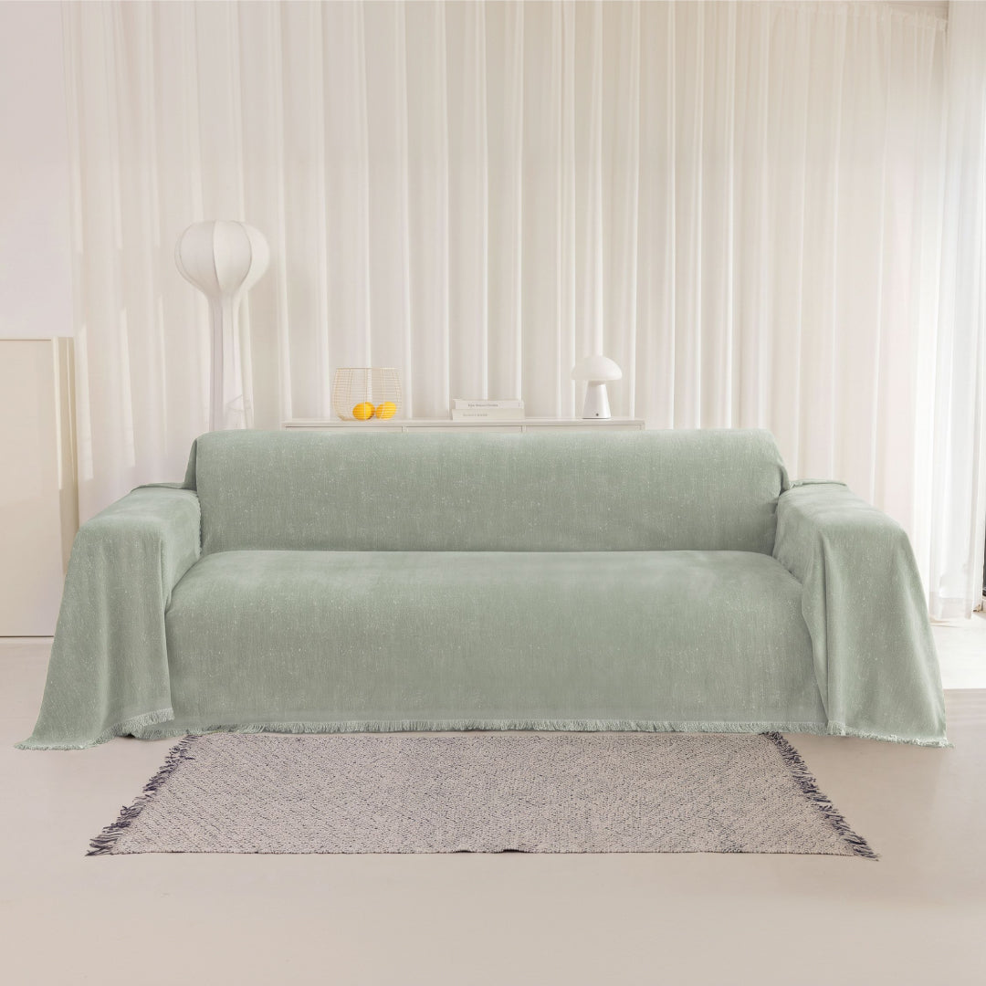 Kale Iris Sprinkle Magic Sofa Blanket draped over a whole sofa in a bright living room