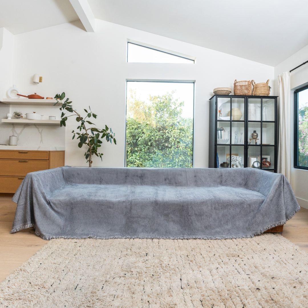 Caviar Sophie Plush Magic Sofa Blanket covering a long sofa in a bright living room