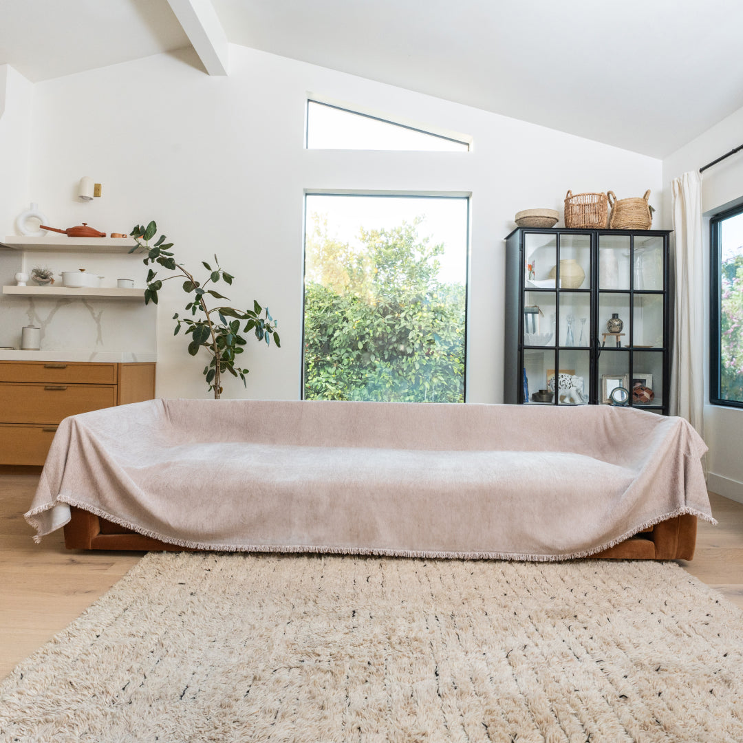 Cookie Sophie Plush Magic Sofa Blanket covering a long sofa in a bright living room