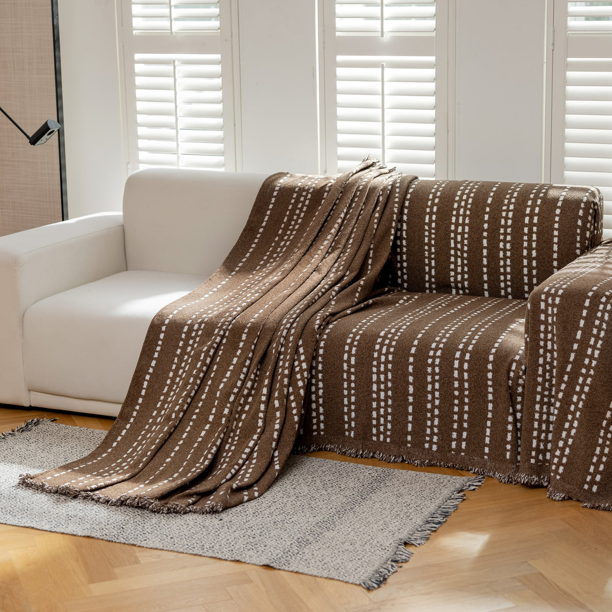 Close-up of the Espresso Noah Stitch Magic Sofa Blanket on a sofa