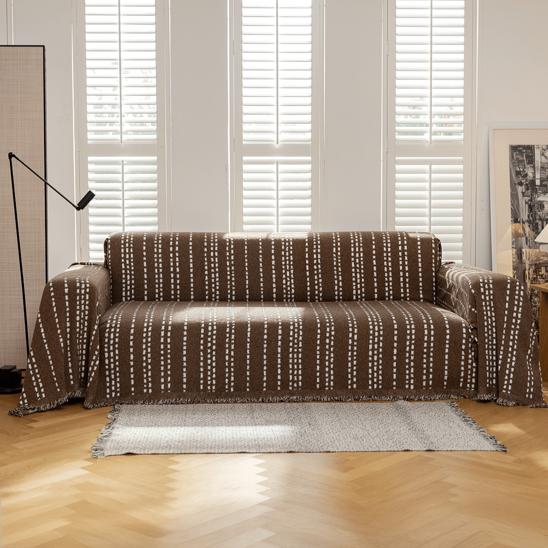 Espresso Noah Stitch Magic Sofa Blanket draped over a sofa in a living room