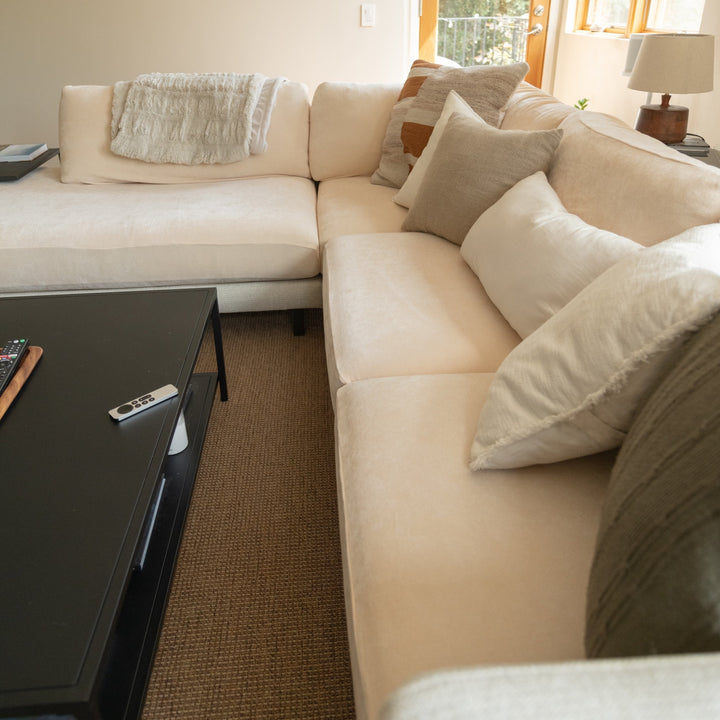 Miracle Sofa Cover Plush in Oatmeal on a corner sectional with throw pillows in a living room