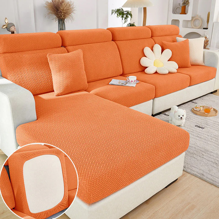 Chaise sectional with orange textured stretch covers and matching pillows in a bright living room