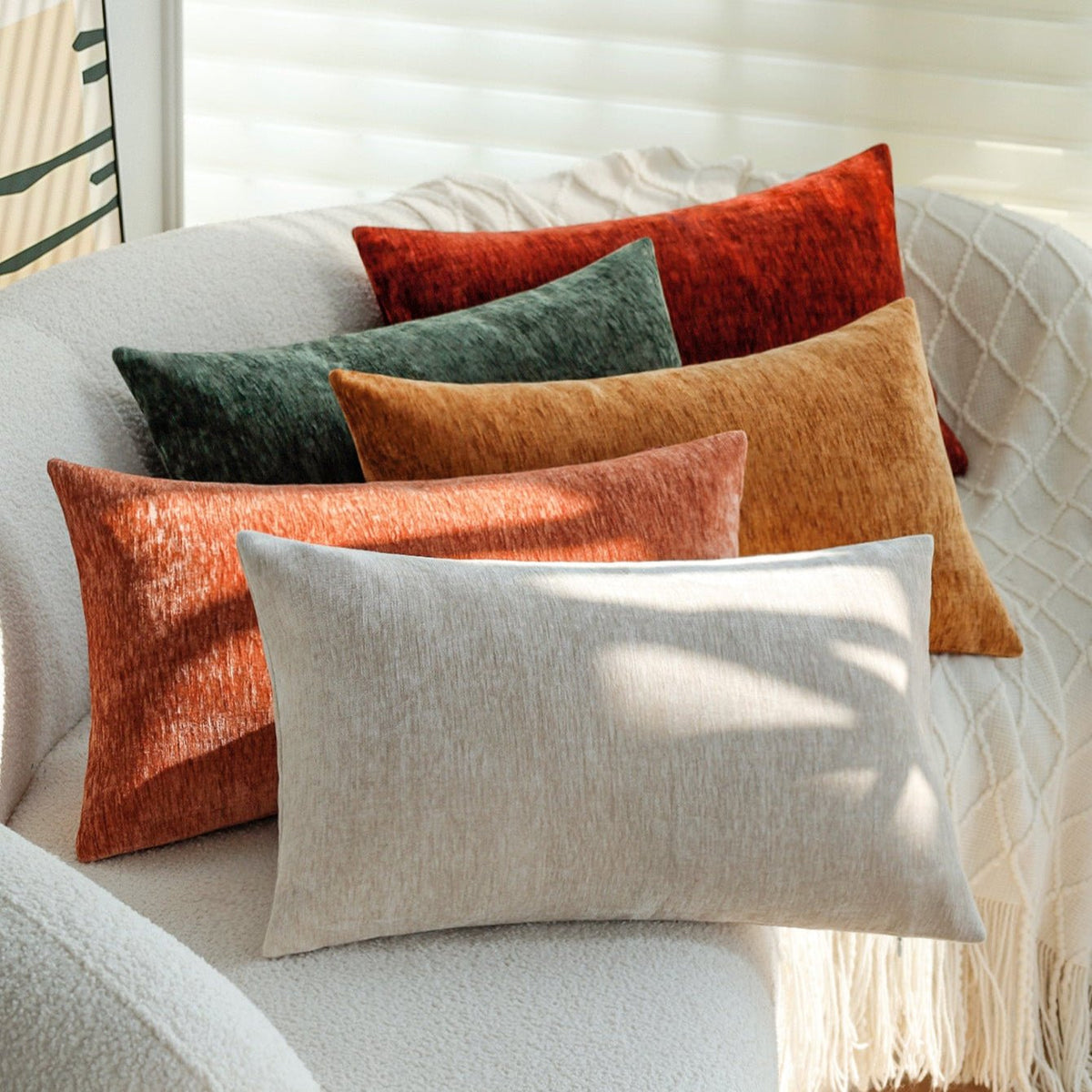 Woody lumbar pillow covers in red, green, mustard, terracotta and light grey on a white boucle chair