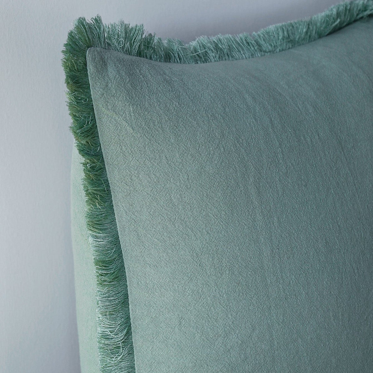 Close-up of a Fringe pillow cover in Sage showing the fringed edge