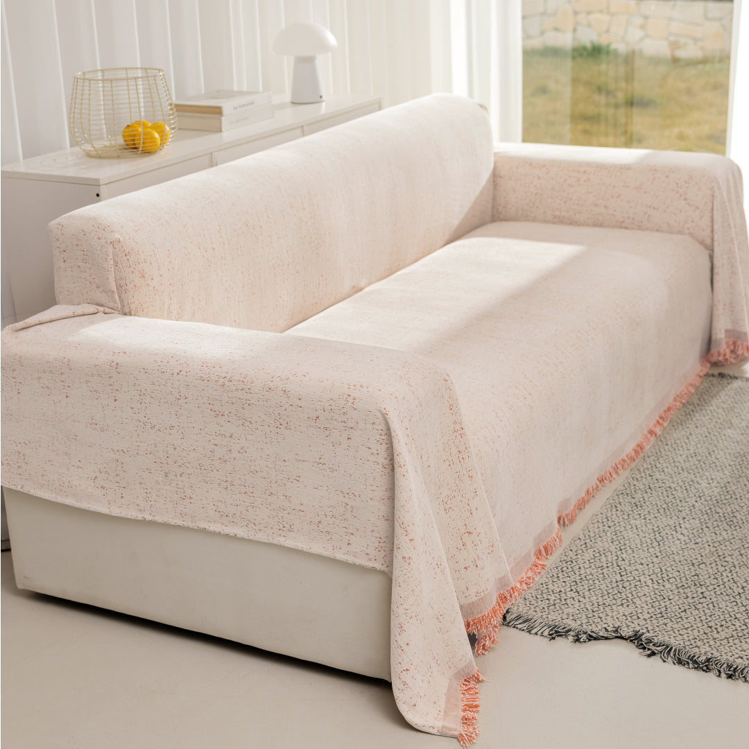 Cinnamon Iris Sprinkle Magic Sofa Blanket covering a sofa beside a grey woven rug