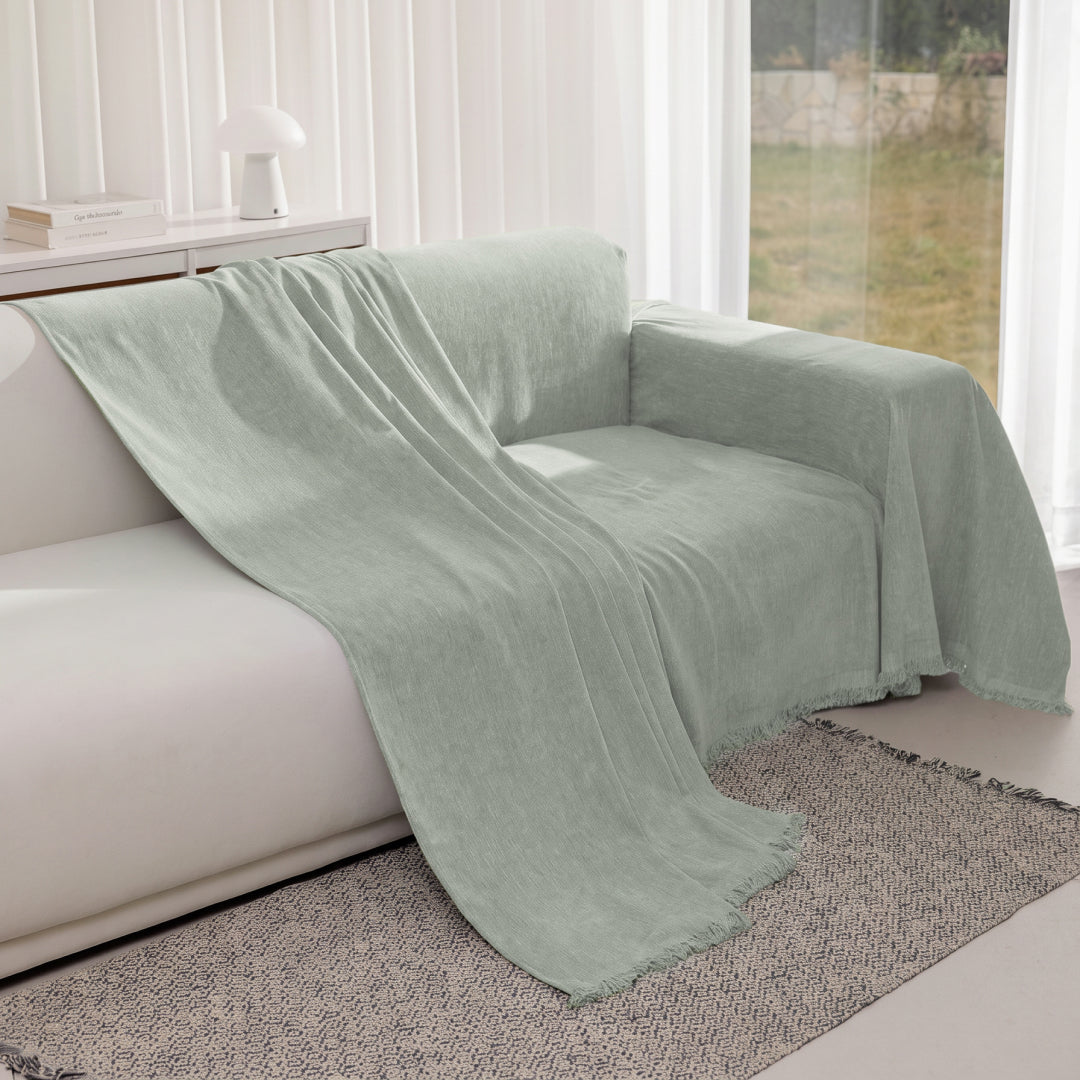 Kale Iris Sprinkle Magic Sofa Blanket partly pulled back to show a white sofa underneath