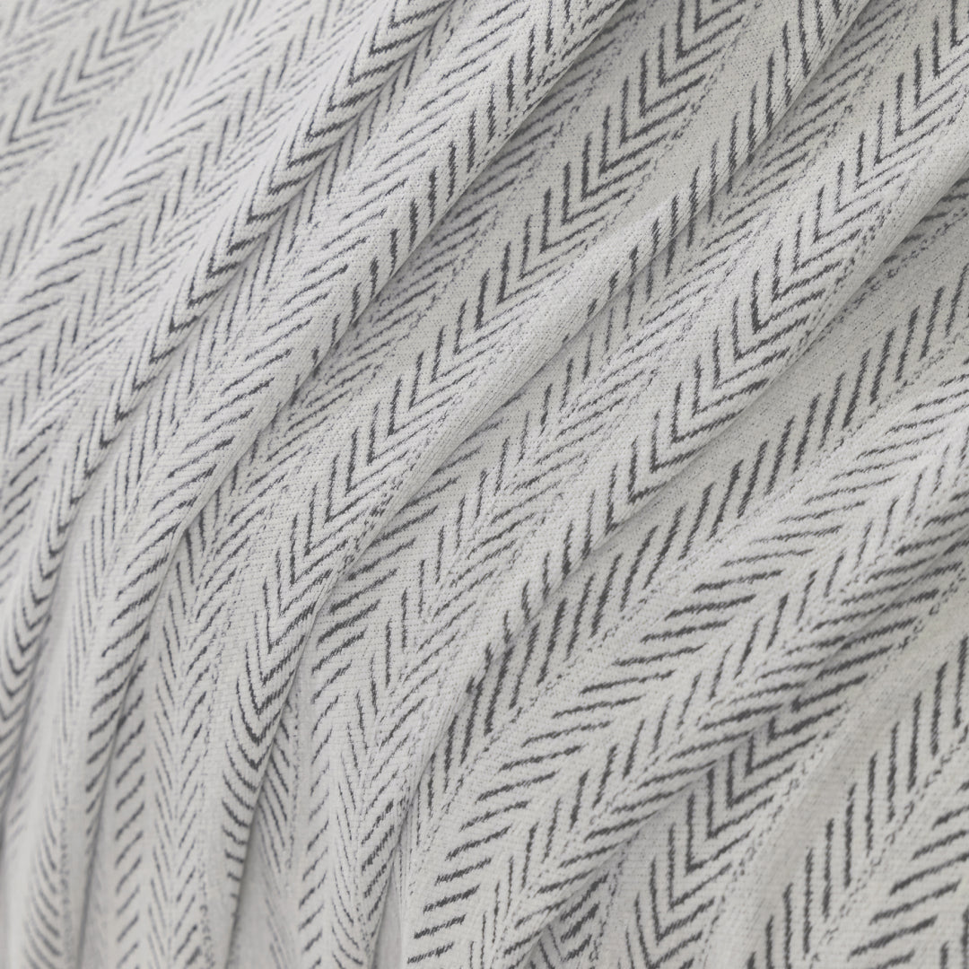 Close-up of Caviar Lena Herring Magic Sofa Blanket fabric, off-white with a charcoal herringbone weave