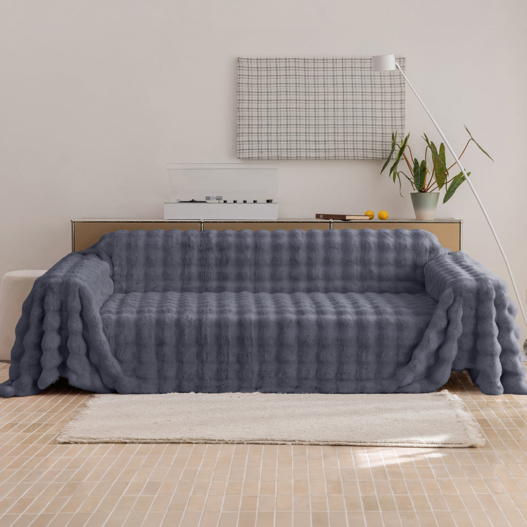 Black Sesame Nora Mink Magic Sofa Blanket draped over a sofa