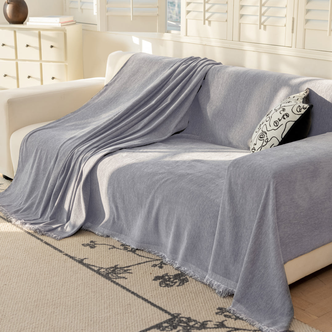 Caviar Sophie Plush Magic Sofa Blanket draped over one seat of a cream sofa