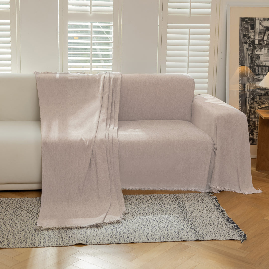 Cookie Sophie Plush Magic Sofa Blanket draped over one seat of a cream sofa