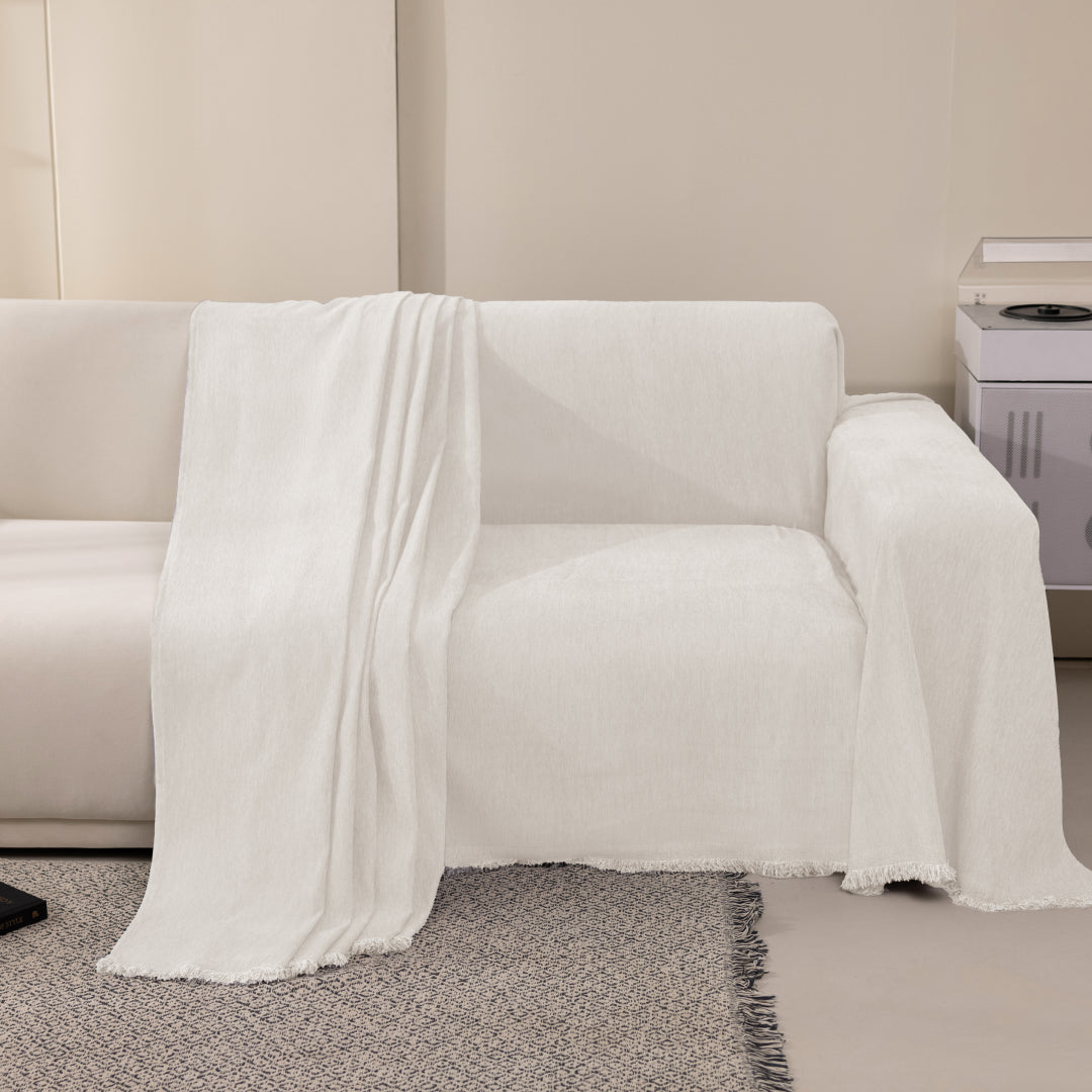 Vanilla Sophie Plush Magic Sofa Blanket draped over one seat of a cream sofa