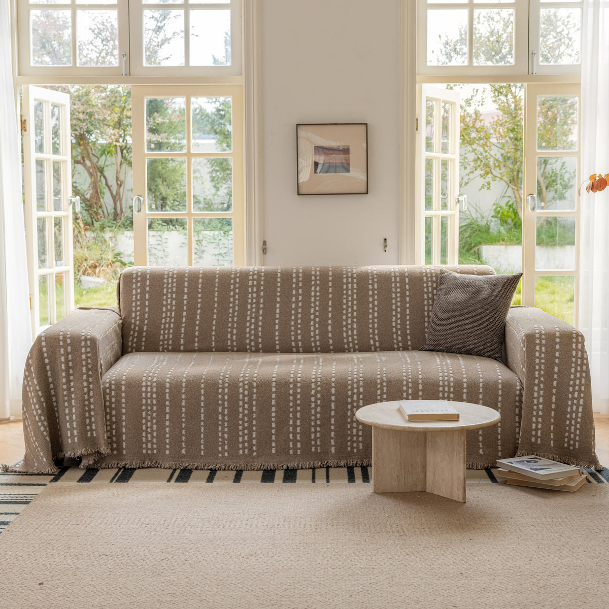 Oat Noah Stitch Magic Sofa Blanket draped over a sofa in a living room