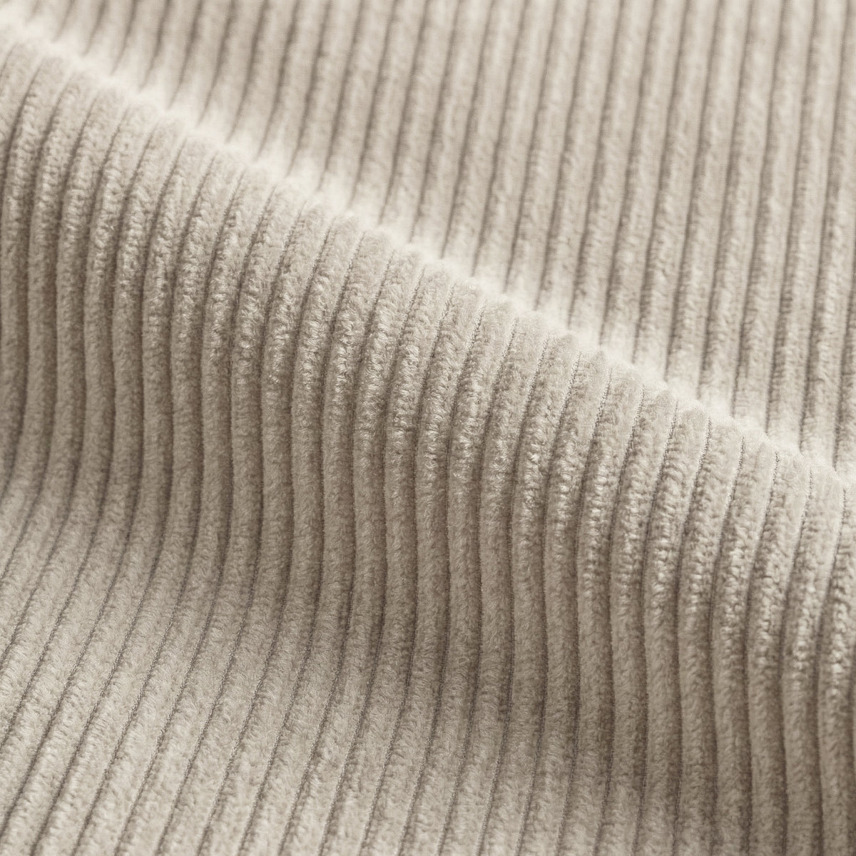 Corduroy fabric swatch in Cream draped in soft folds