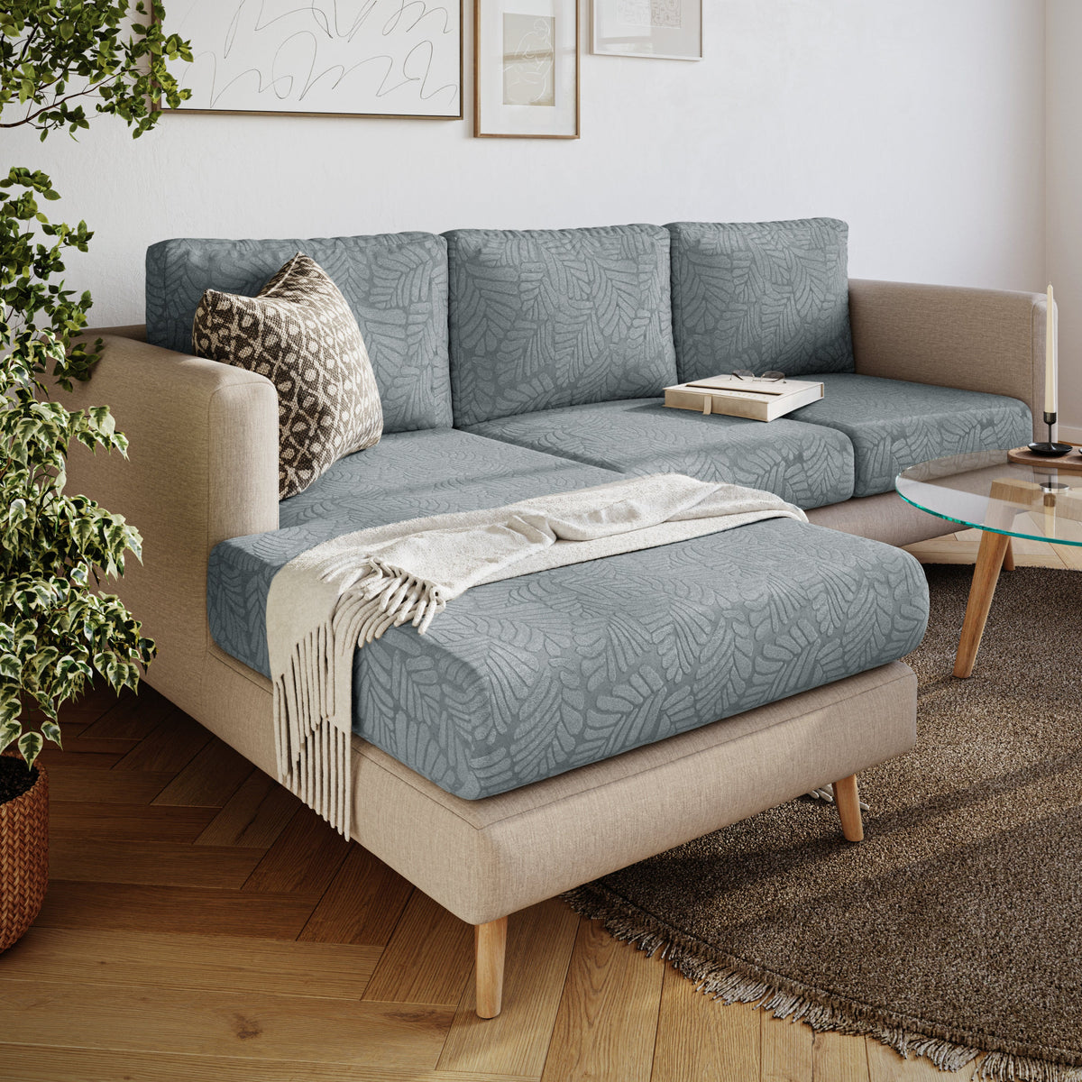 Magic Sofa Cover in Leaf pattern, blue-grey, on a beige chaise sectional in a living room