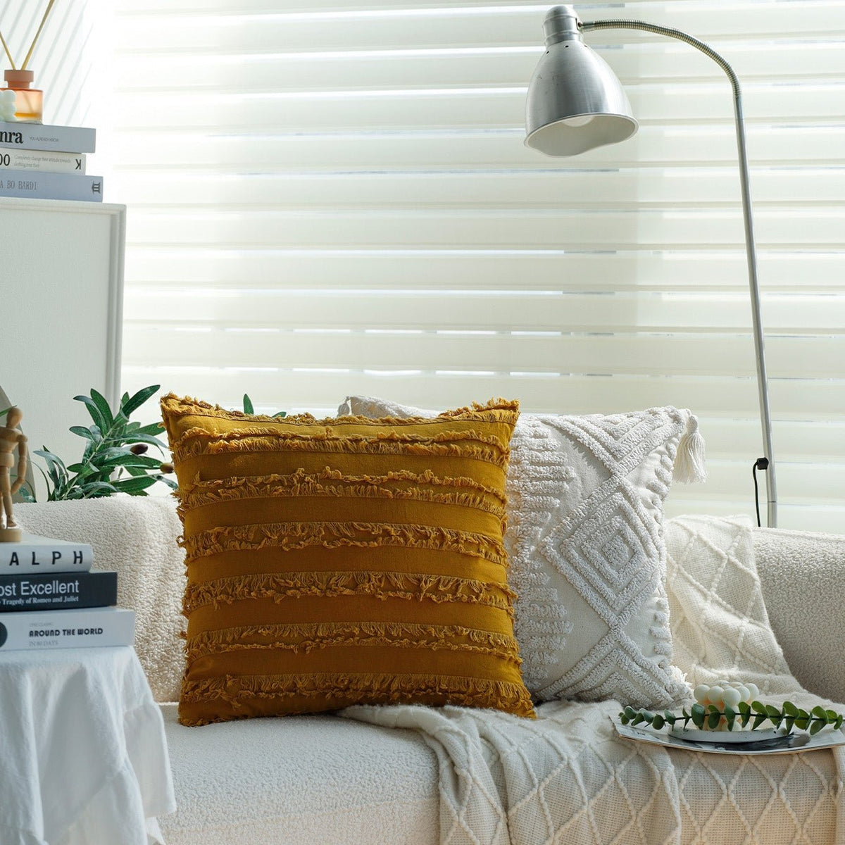 Reeve pillow cover in Mustard with a white tufted pillow on a sofa by a window