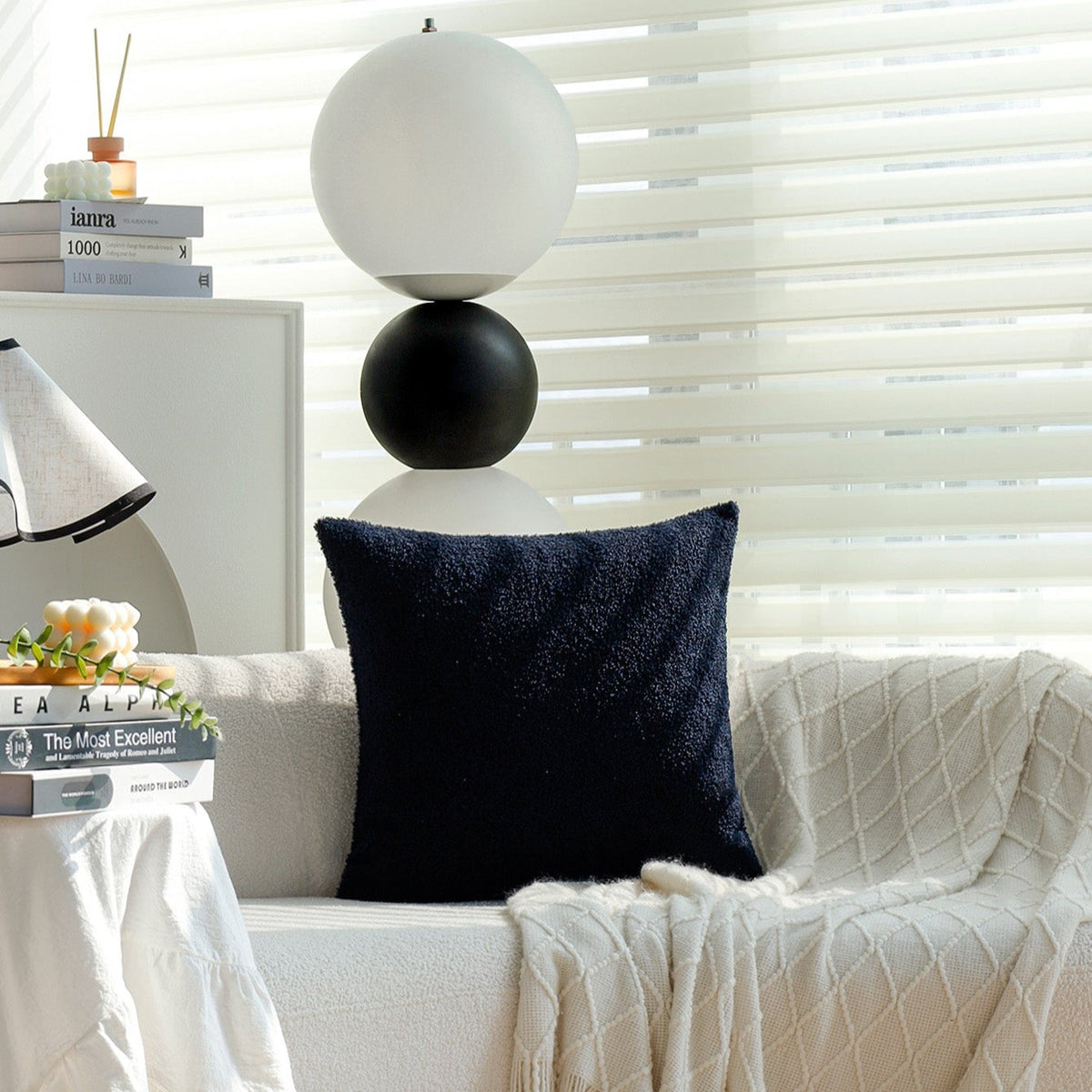 Teddy pillow cover in Navy on a cream sofa with a knit throw in a bright living room