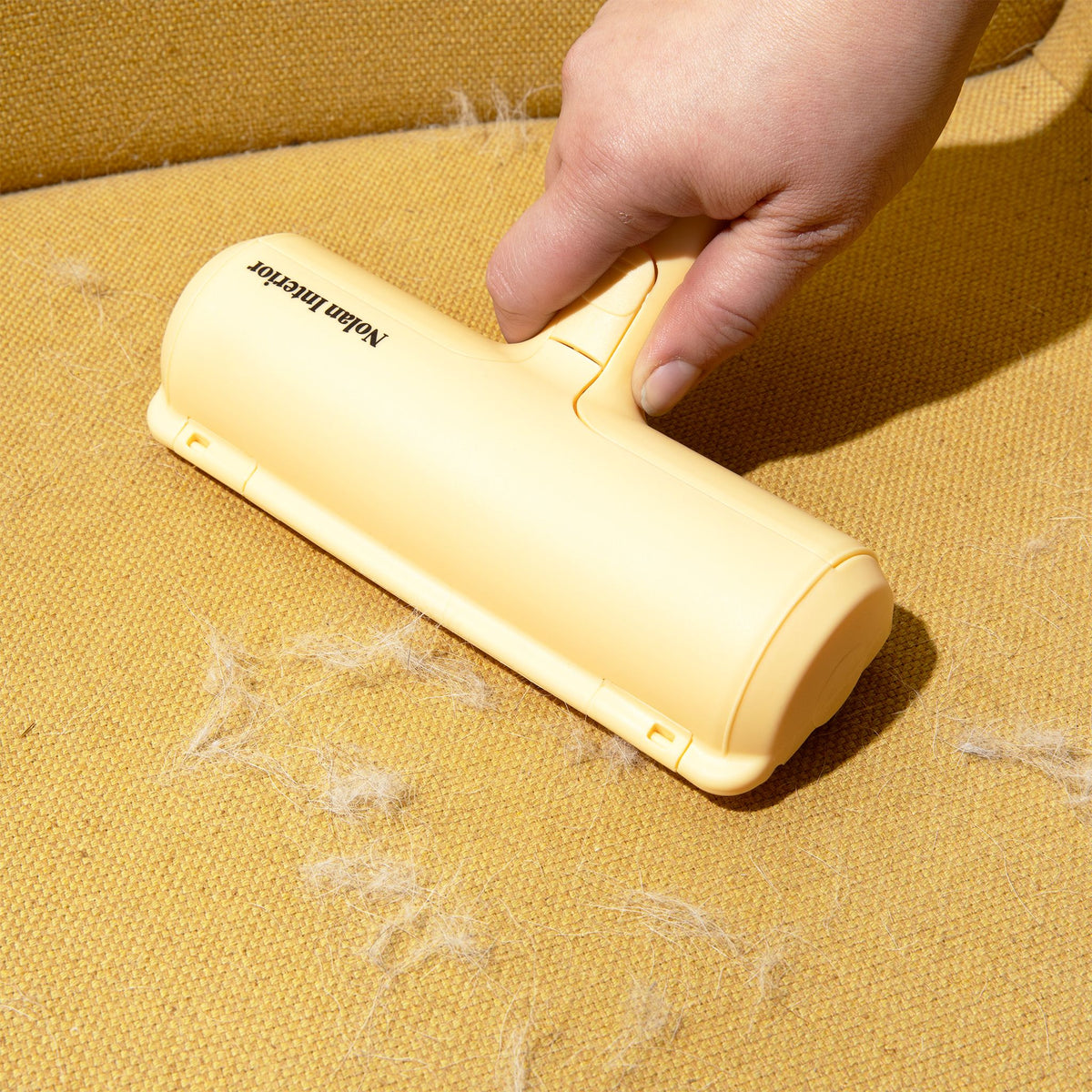 Magic Pet Hair Remover rolling pet hair off a woven chair seat