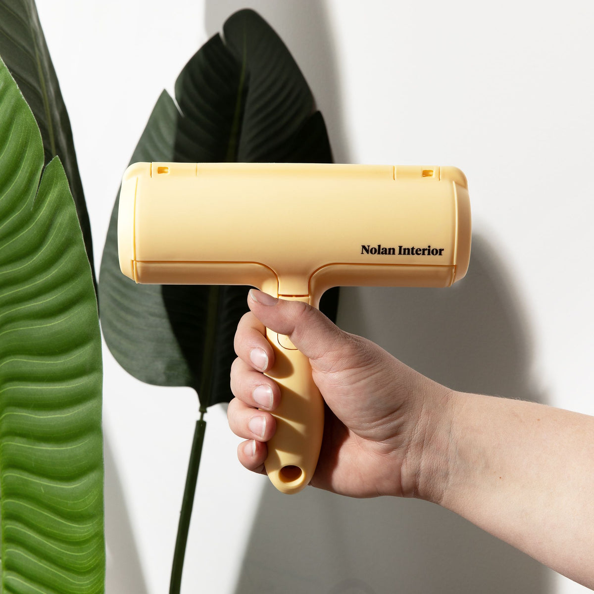 Hand holding the pale yellow Magic Pet Hair Remover