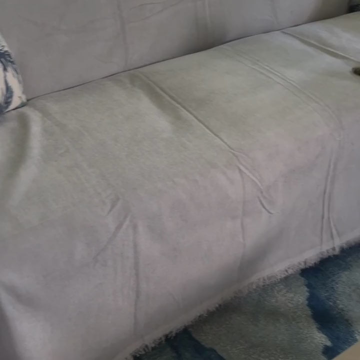 Magic Sofa Blanket tucked into the seat crease, with a cat