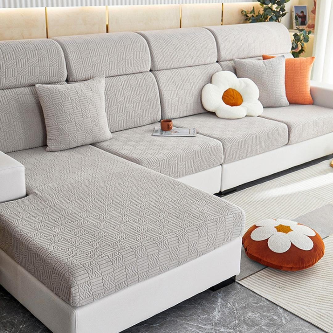 Light grey stretchable couch cover in a contemporary living room setting.