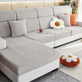 Light grey stretchable couch cover in a contemporary living room setting.