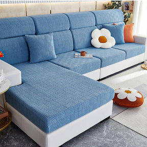 Blue stretchable couch cover in a contemporary living room setting.