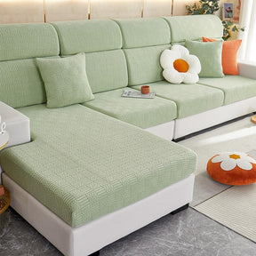 Green stretchable couch cover in a contemporary living room setting.