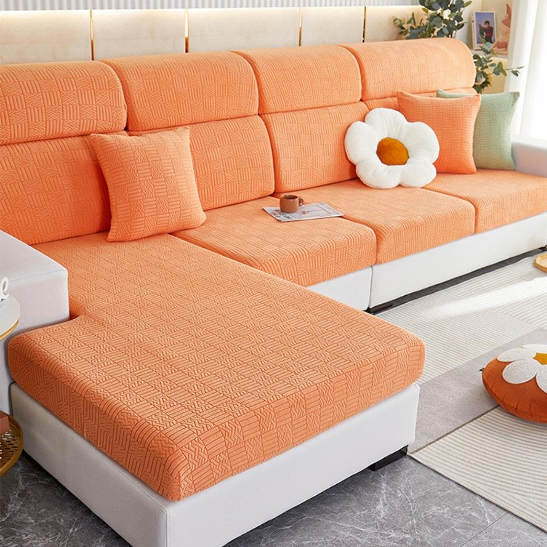 Orange stretchable couch cover in a contemporary living room setting.