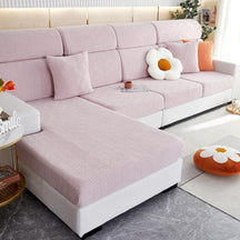 Pink stretchable couch cover in a contemporary living room setting.