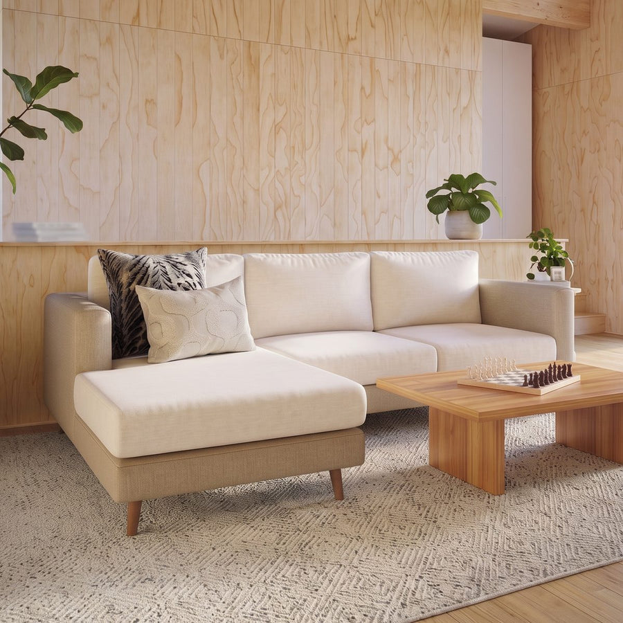 Miracle Sofa Cover Plush in Cream on a beige chaise sectional in a wood-panelled living room
